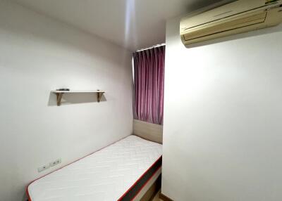 Small bedroom with a single bed, air conditioner, and shelf