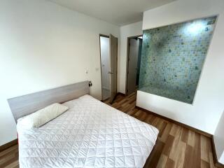 Minimalistic bedroom with wooden flooring and a mosaic-tiled partition