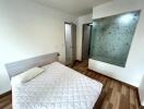 Minimalistic bedroom with wooden flooring and a mosaic-tiled partition