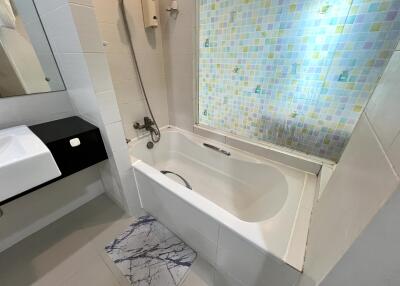 Modern bathroom with bathtub and colorful tiled wall