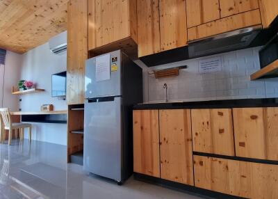 Modern kitchen with wooden cabinets and stainless steel refrigerator