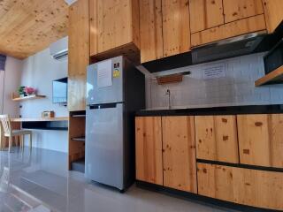 Modern kitchen with wooden cabinets and stainless steel refrigerator