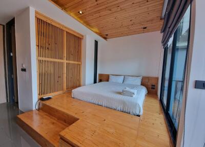 Modern bedroom with wooden ceiling and raised platform bed