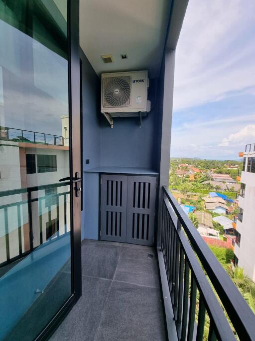 Modern balcony with outdoor AC unit and glass door