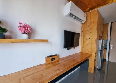 Modern living area with wooden accents, air conditioning, and wall-mounted TV