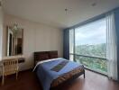 Spacious bedroom with large window and scenic view