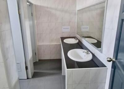 Modern bathroom with double sinks and stall partitions