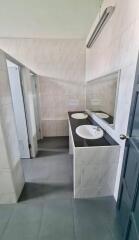 Modern bathroom with double sinks and stall partitions