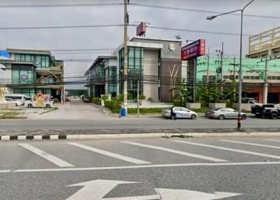 Commercial buildings along a main road with parking spaces