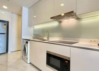 Modern kitchen with sleek white cabinetry, integrated appliances, and tiled flooring.