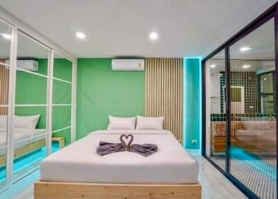 Modern bedroom with green accent wall and large bed
