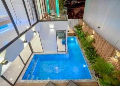 Beautifully lit modern outdoor pool area with greenery