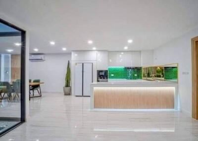 Modern kitchen with white cabinets, green backsplash, and island