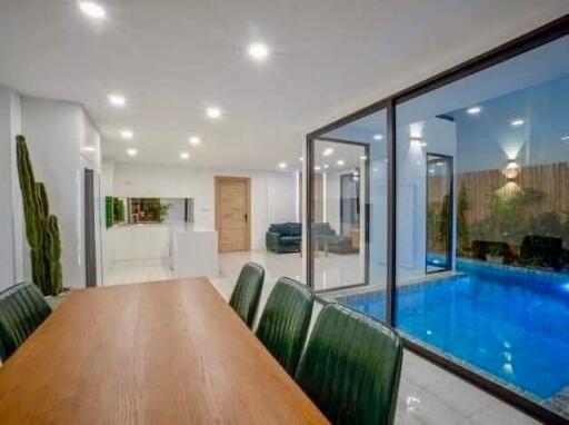 Modern dining area with large table and view of indoor pool