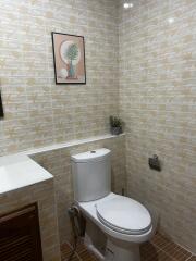 Neat bathroom with tiled walls and a modern toilet