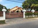 Exterior view of a house with red roof and wooden gate