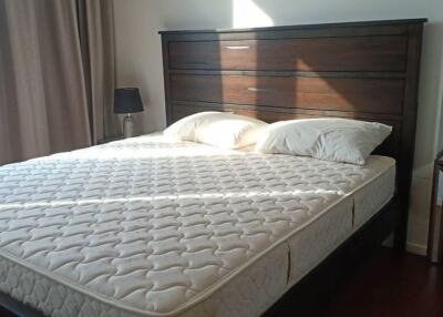 Bedroom with a large bed, dark wooden headboard, and nightstands with lamps