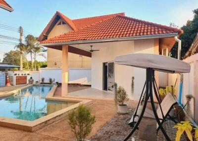 Outdoor view of house with swimming pool and swing chair