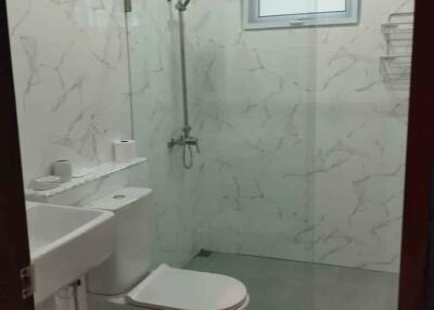 Modern bathroom with glass shower and marble wall tiles