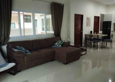 Modern living room with brown sectional couch and dining area