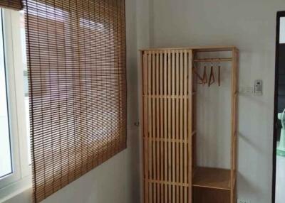 Wooden wardrobe in a bedroom with window and blinds
