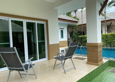 Covered patio area with pool in the background