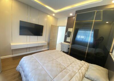 Modern bedroom with mounted TV and large bed