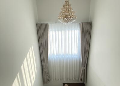 Stairwell with chandelier and window