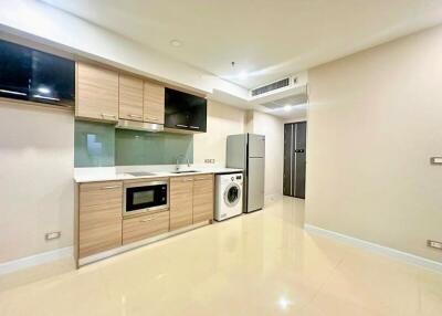 Modern kitchen with wooden cabinets, built-in appliances, and a washing machine