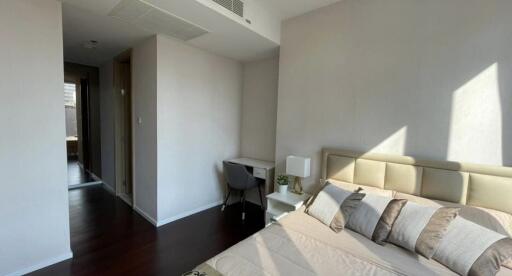 Modern bedroom with a bed, study desk, chair, and natural light