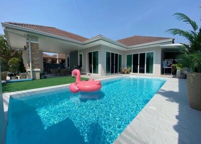 Modern house with a swimming pool and a pink flamingo float.