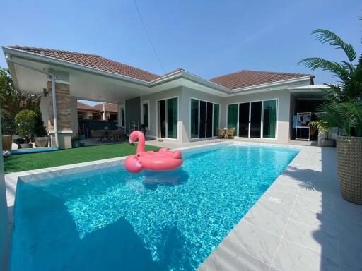 Modern house with a swimming pool and a pink flamingo float.