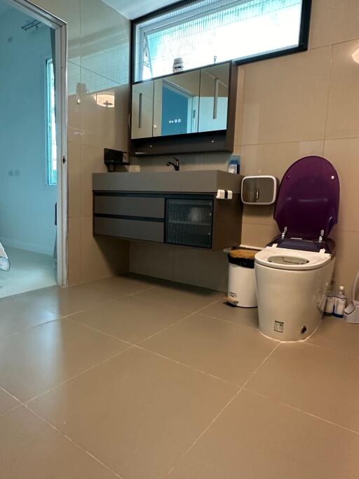 Modern bathroom with vanity, toilet, and window