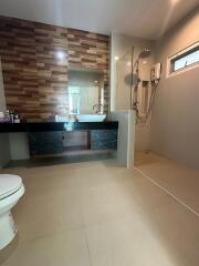 Modern bathroom with wooden accent wall and walk-in shower