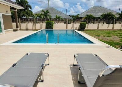 Outdoor pool area with poolside lounge chairs