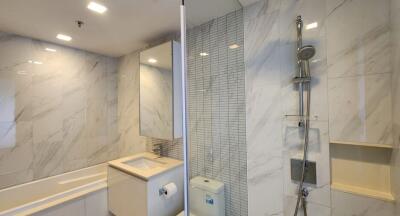 Modern bathroom with large mirror, bathtub, shower, and contemporary fixtures