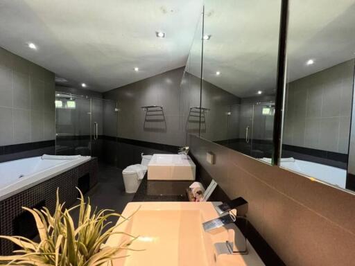 Modern bathroom with large mirror, spacious tub, and double sinks