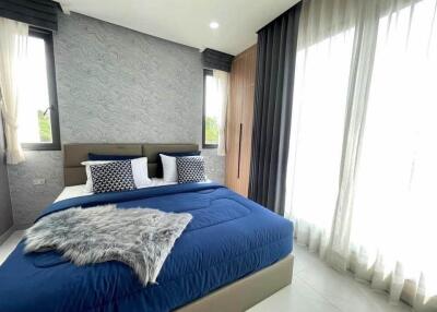 Modern bedroom with blue bedding and large windows