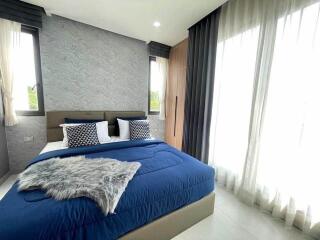 Modern bedroom with blue bedding and large windows