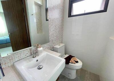 Modern bathroom with sink, mirror, and toilet
