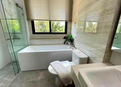 Modern bathroom with large bathtub, glass shower, and vanity