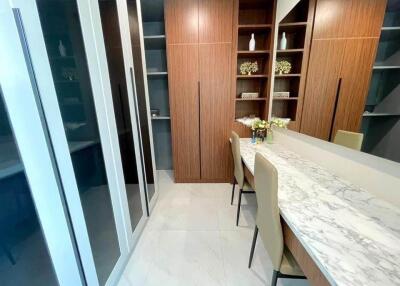 Spacious dressing room with built-in wooden wardrobes and a marble-topped vanity table