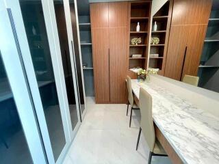 Spacious dressing room with built-in wooden wardrobes and a marble-topped vanity table