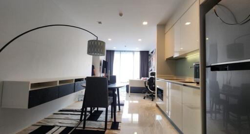 Modern living area and kitchen with dining table and large refrigerator