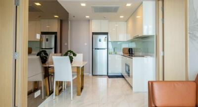 Modern kitchen and dining area with white cabinets and stainless steel appliances