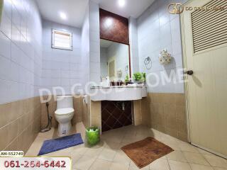 Modern bathroom with a large mirror, toilet, and sink