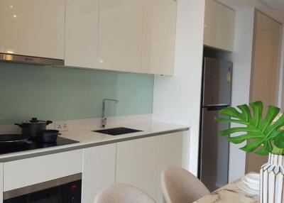 Modern kitchen with white cabinetry, built-in appliances, and a dining area