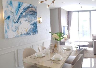 Modern living and dining area with marble table and large wall art