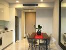 Modern dining area with a table, chairs, and a plant centerpiece