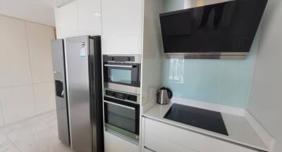 Modern kitchen with built-in appliances and stainless steel refrigerator